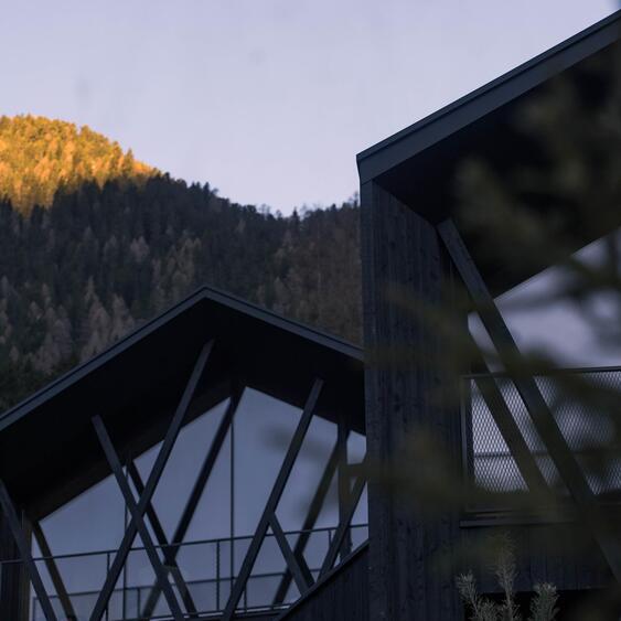 Amus Chalets mit dunklem Holz, großer Glasfront und diagonalen Holzelementen.