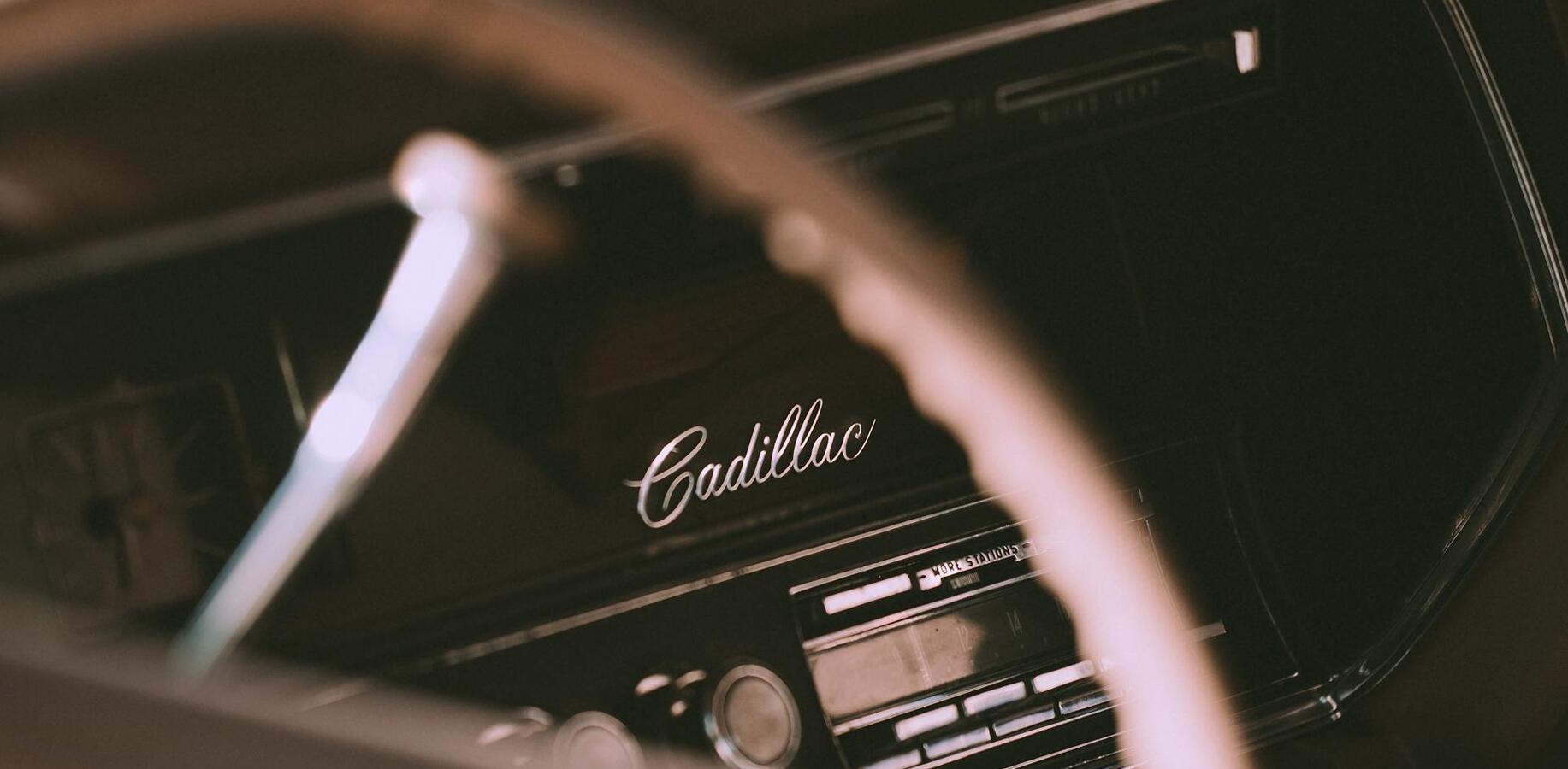 Close-up of the steering wheel and dashboard of a classic Cadillac.