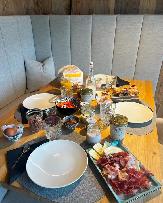 Tavola per la colazione apparecchiata con pietanze dolci e salate nell'Amus Chalet.