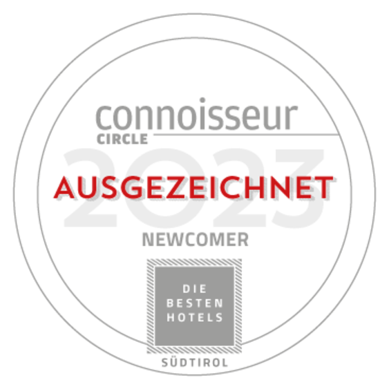 Sigillo di riconoscimento «Connoisseur Circle 2023 – Ausgezeichnet Newcomer» con la scritta «Die besten Hotels Südtirol».